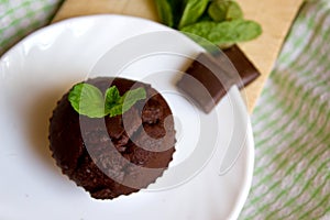 Top View of Chocolate Muffin with Mint Leaves on the Saucer in the Kitchen