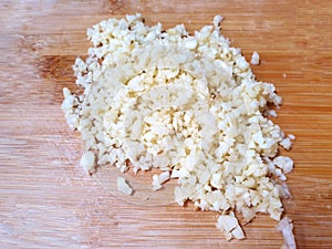 Top view of Chopped garlic on wooden table as a background
