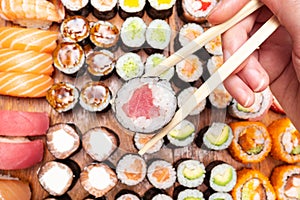 Top view of chopsticks with roll over lot of sushi