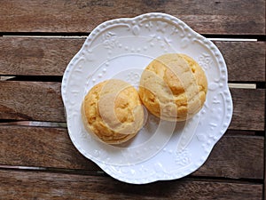Top view of Choux cream in white plate on wooden table in cafÃ© ready to eat