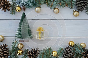 Top view of christmas decoration made from pine tree branch,  decorative balls, pine cones, little toy pine tree and gift box