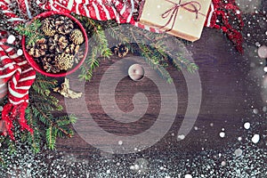 Top view of christmas decoration - red bowl full of fir-cones, gift box wrapped in kraft paper, golden angel, pine branches, candl