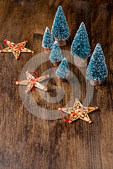 Top view Christmas decoration, with stars and trees, on dark wooden table