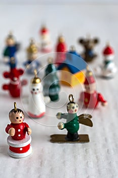 Top view of Christmas figurines, the first ones focused, the others in bokeh, on white background