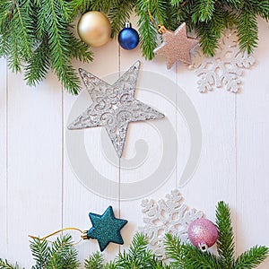 Top view of Christmas fir and stars frame / border on a shabby white wooden table. Place for your text or product. Close-up,