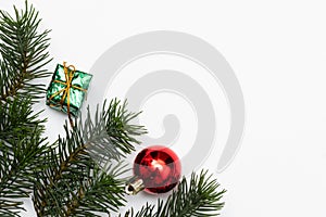 Top view of Christmas gift box red balls with spruce branches, pine cones, red berries and bell on white background