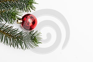 Top view of Christmas gift box red balls with spruce branches, pine cones, red berries and bell on white background