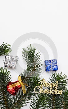 Top view of Christmas gift box red balls with spruce branches, pine cones, red berries and bell on white background