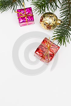 Top view of Christmas gift box red balls with spruce branches, pine cones, red berries and bell on white background