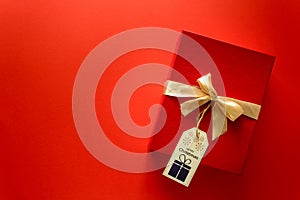 Top view on Christmas gifts wrapped in gift paper decorated with ribbon on red paper background