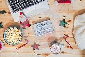 Top view Christmas Movie night concept. Flat lay composition with Movie night message on the board, laptop, popcorn bowl