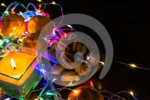 Top view. Christmas New Year Composition with Tangerines candle, garlands, colorful lights, selective focus Black Background