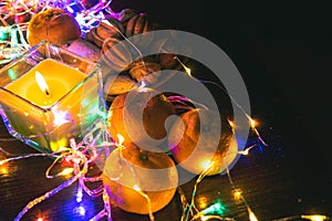 Top view. Christmas New Year Composition with Tangerines candle, garlands, colorful lights, selective focus Black Background