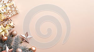 Top view Christmas tree branch, gift box, festive decorations on brown background. Minimal flat lay style composition with copy