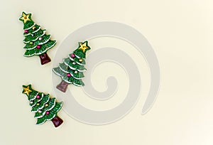 top view Christmas trees on light yellow background. Free copy space. Concept of decoration, greeting cards