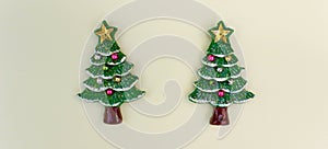 top view Christmas trees on light yellow background. Free copy space. Concept of decoration, greeting cards