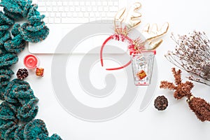 Top view of Christmas and winter shopping online concept on white desk. White laptop, shopping cart, gift boxes, notebook