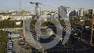 Top view of city with modern buildings and construction. Stock footage. Construction site of building with cranes in