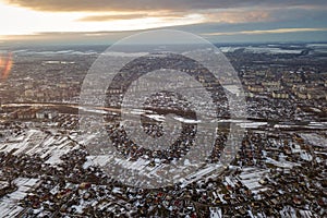 Top view of city suburbs or small town nice houses on winter morning on cloudy sky background. Aerial drone photography concept