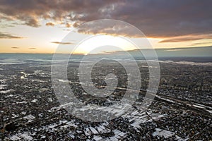 Top view of city suburbs or small town nice houses on winter morning on cloudy sky background. Aerial drone photography concept