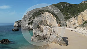 Top view of cliffs and rocks on an empty beach in Sesimbra, Portugal