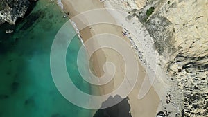 Top view of cliffs and rocks on an empty beach in Sesimbra, Portugal