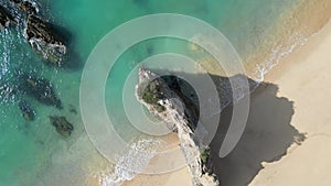 Top view of cliffs and rocks on an empty beach in Sesimbra, Portugal