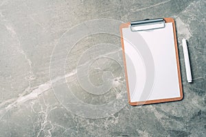 Top view of clipboard, paper, pen on marble background with copy space. Top view, copy space. Blogger, feminine business concept.