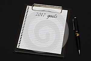 Top view of clipboard and white sheet written with 2017 goals on