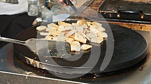 Greek vender grilling ,squares of flatbread at a topical farmers market photo