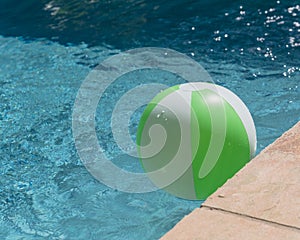 Top view close-up beach ball near swimming pool coping