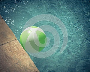 Top view close-up beach ball near swimming pool coping