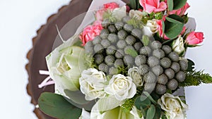 Top view, close-up of a bouquet of flowers, rotation , consists of eucalyptus, cineraria, Rose cream grace, Rose