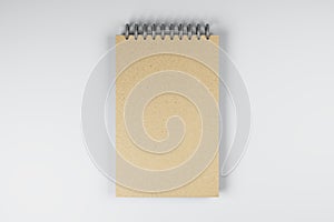 Top view and close up of brown spring notepad on white desktop background. Mock up place for your advertisement. Education, work,