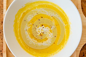 Top view close up of Classic Pureed Pumpkin Soup topping with Milk, Cream and Pepper
