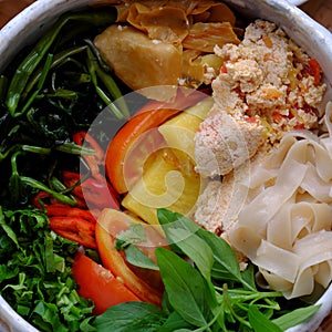 Close up dry paper noodles soup bowl, tofu, pine apple, tomato, water spinach