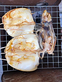 Top view with close up fresh squid grill on the clay firepot for dinner BBQ