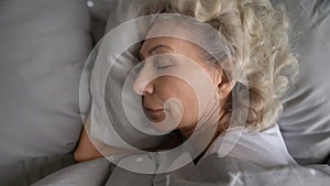 Top view close up peaceful beautiful mature woman sleeping