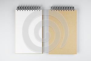 Top view and close up of two white and brown spring notepads on white desktop background. Mock up place for your advertisement.