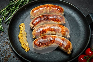 Top view closeip fried sausages on round pan with granular mustard