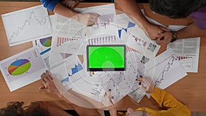 Top view closeup of boardroom desk with young male and female workers talking using tablet. Advertising area workspace