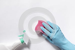 Top view closeup of cleaning gloves, sponge, and spray bottle on a white background