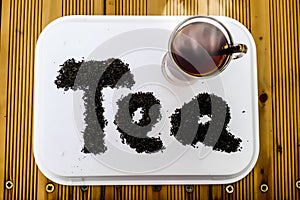 Top View closeup of Hot cup of tea with written word tea by tea leaf