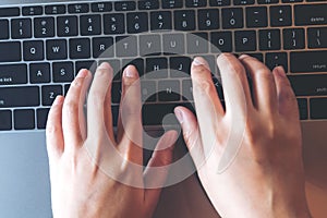 Top view closeup image of business woman`s hands typing on laptop