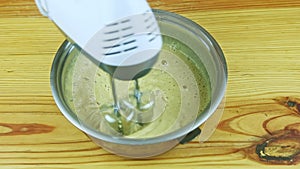 top view closeup at man hands by electric mixer mixing liquid dough in big saucepan