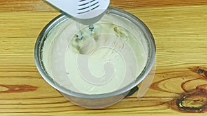 top view closeup at man hands by electric mixer mixing liquid dough in big saucepan