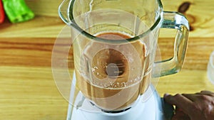 Top view closeup at man hands turn on electric blender mixing chopped vegetables