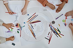 Top view closeup at multiethnic group of children doing arts and crafts at table