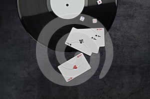 Top view and closeup of palying cars, dice, dark vinyl record on the pocker table