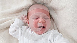 Top view closeup shot of newborn baby boy crying beacuse of feeling hungry